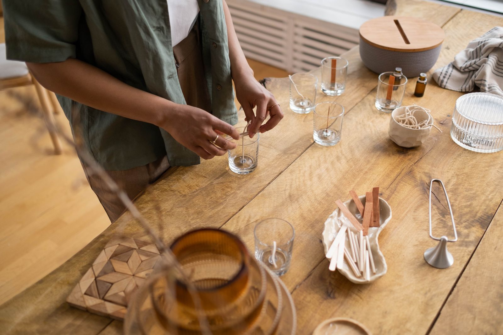 A hand-poured candle glowing in a cozy rustic setting
